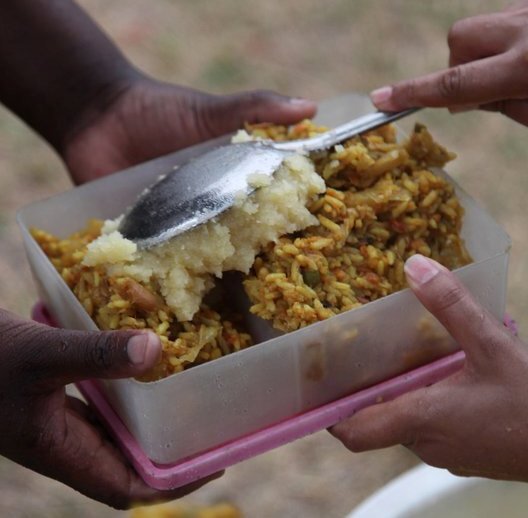 A photograph of prasada rice being served from a shared container, used on gaudiyahistory.iskcondesiretree.com's biography page for Kali Das — chosen for this page because it evokes the sharing and receiving of maha-prasada that is the culm