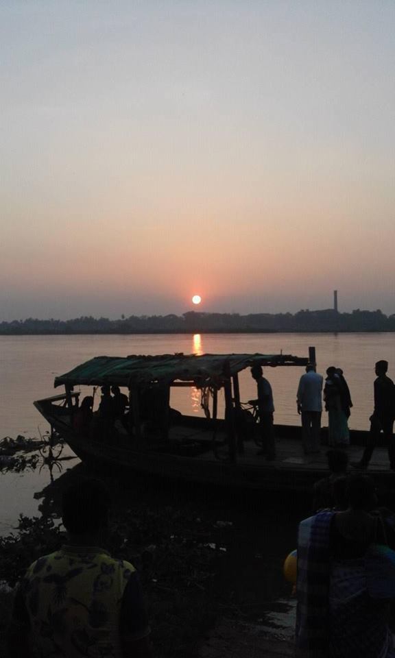A modern photograph of a boat crossing the Ganges at sunset by Halisahara (Kumarahatta), Shivananda Sena's actual native village on the river.